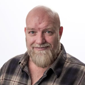 Portrait of a bald man with beard and plaid shirt